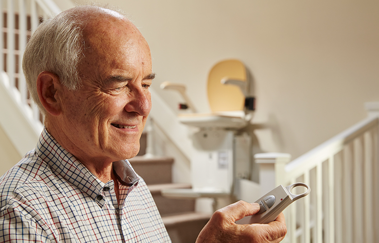 Customer using remote control to operate stairlift